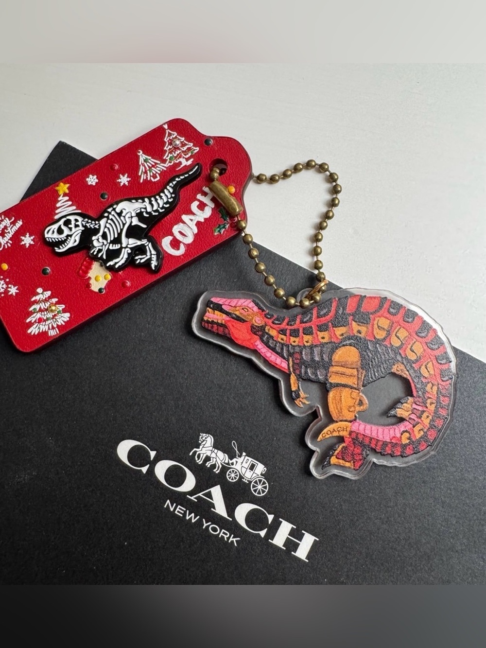 Coach Christmas Dinosaur Keychain with red rexy graphic charm